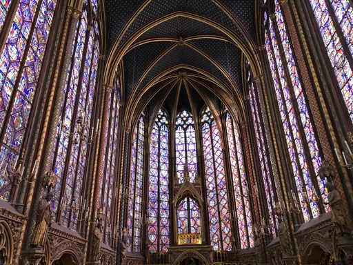 Floor-to-ceiling stained glass windows rising into the vaulted ceiling of the Sainte-Chapelle.